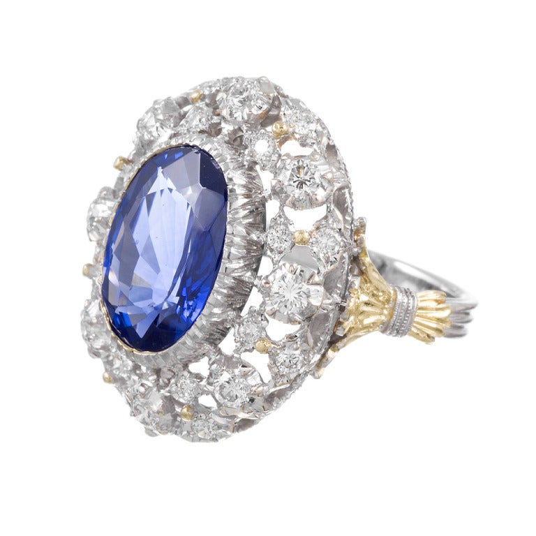 Classic and recognizable Buccellati piece, set with a medium blue oval sapphire of 6 carats and framed by diamond lace. An important piece of signed jewelry offered in ints original presentation box.