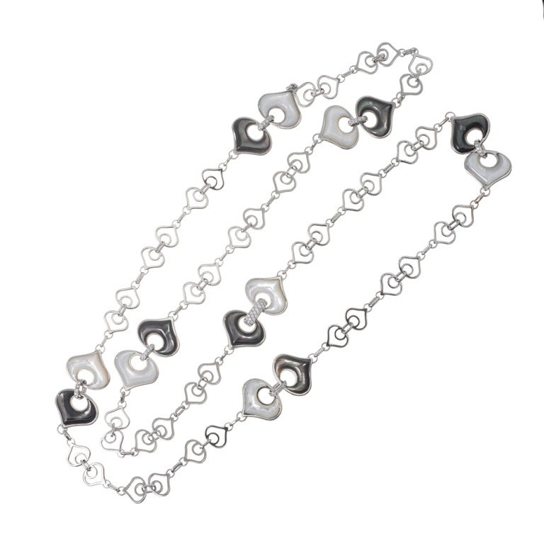 Stylized spade-shaped links of 18k white gold, spaced with larger sections that are set with white and black mother of pearl and decorated with diamonds. Signed Marina B, this necklace is a great example of fine jewelry that is suitable for daily