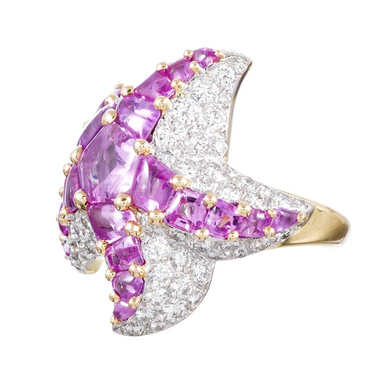 18k white and yellow gold ring, designed as a star wrapped around your finger, with unfaceted, custom cut pink sapphires comprising the body and brilliant white diamonds forming the three-dimensional background. The diamonds weigh 2.97 carats and