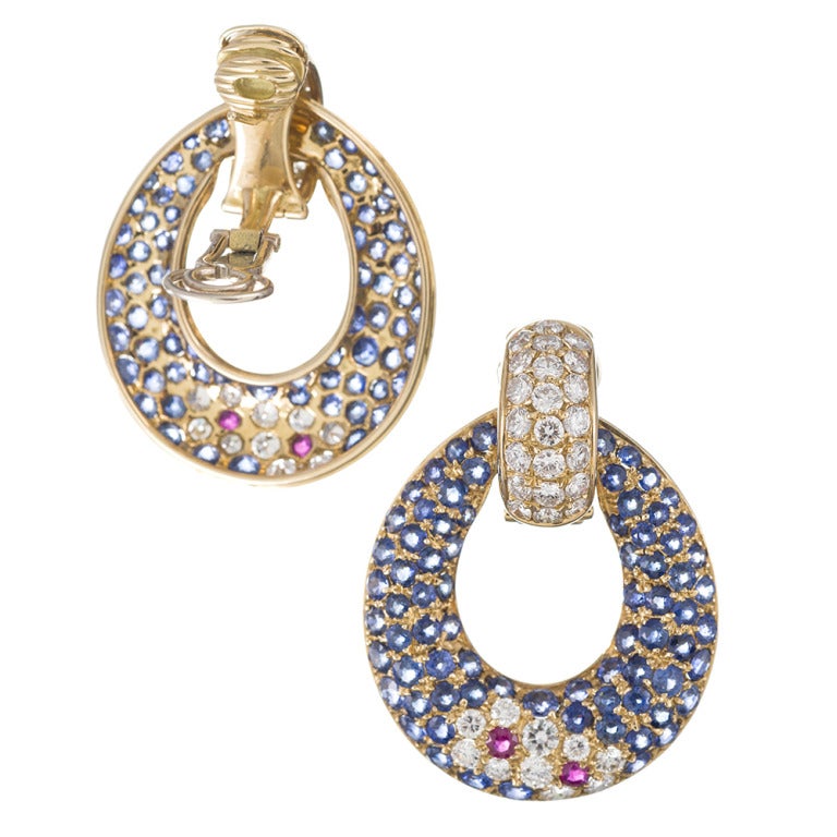 Fine jewelry with playful style: 18k yellow gold modified hoop earrings, set with 4.80 carats of brilliant F/Vs diamonds, 14.46 carats of sapphires and .32 carats of ruby. This classic 