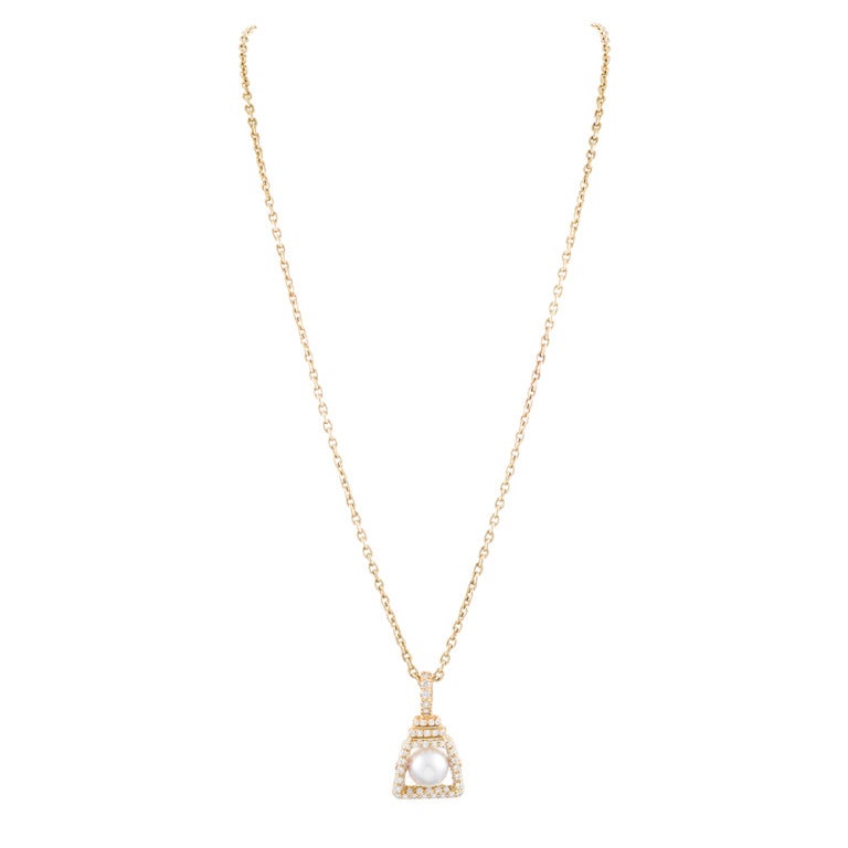 Henry Dunay has done it again, creating a lovely Pearl and Diamond Drop Pendant on an 18 karat yellow gold chain measuring approximately 20 inches in length. The diamond weight total is 2 carats surrounding a 11 mm pearl to create a classic