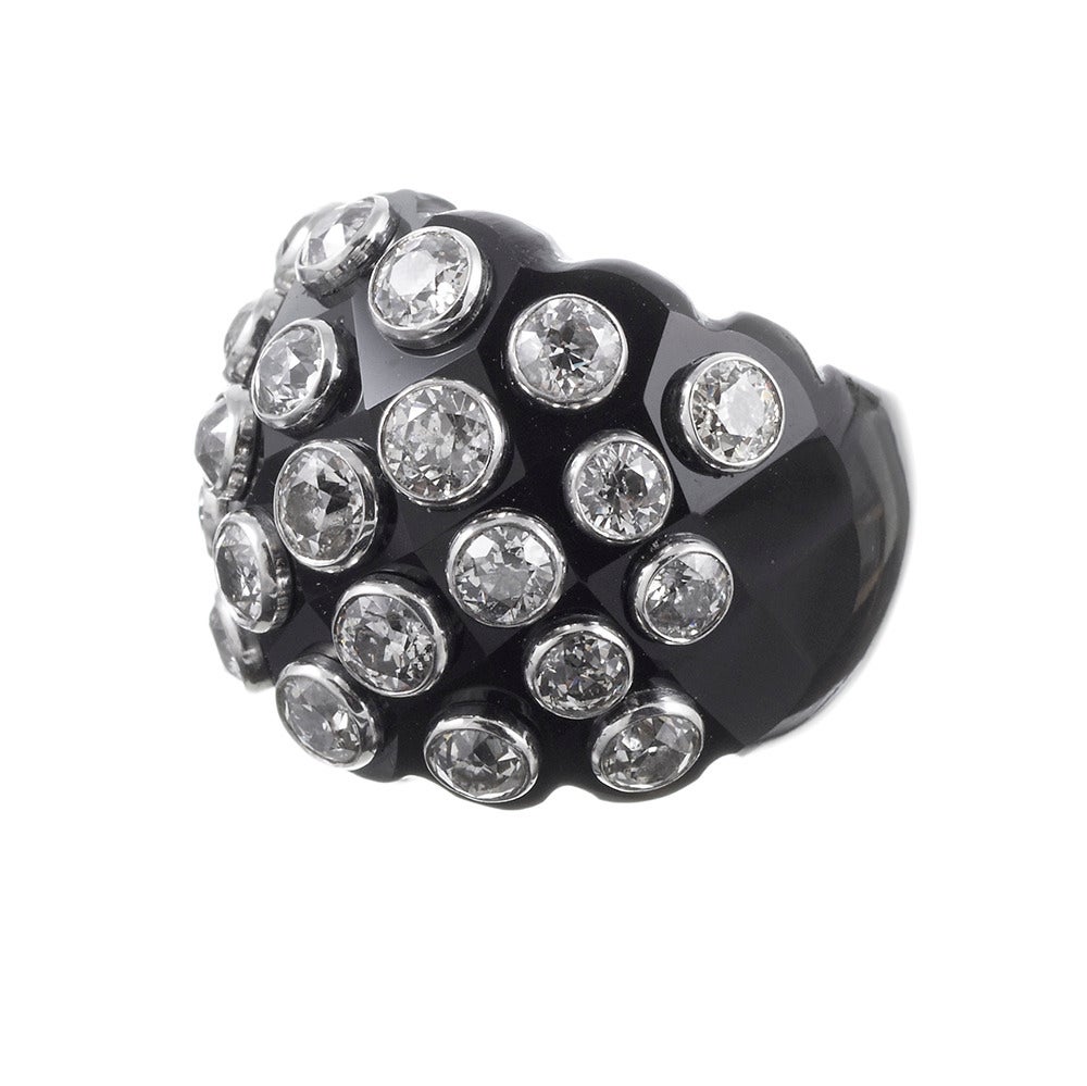 This ring is created by carving a tapered sphere from a solid piece of onyx, then decorated with bezel set diamonds. In total, 6.41 carats of brilliant round diamonds lend a nod of fancy to this chic organic creation. The ring is a size 7 and cannot