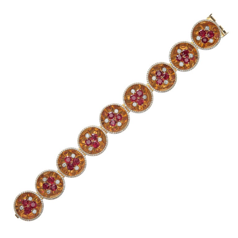 A truly impressive bracelet design incorporating saucer-like links coupling together fine rubies and diamonds in this unique cluster style adaptation. The clusters altogether possess twenty-seven (27) burmese rubies weighing over 8.00 carats in