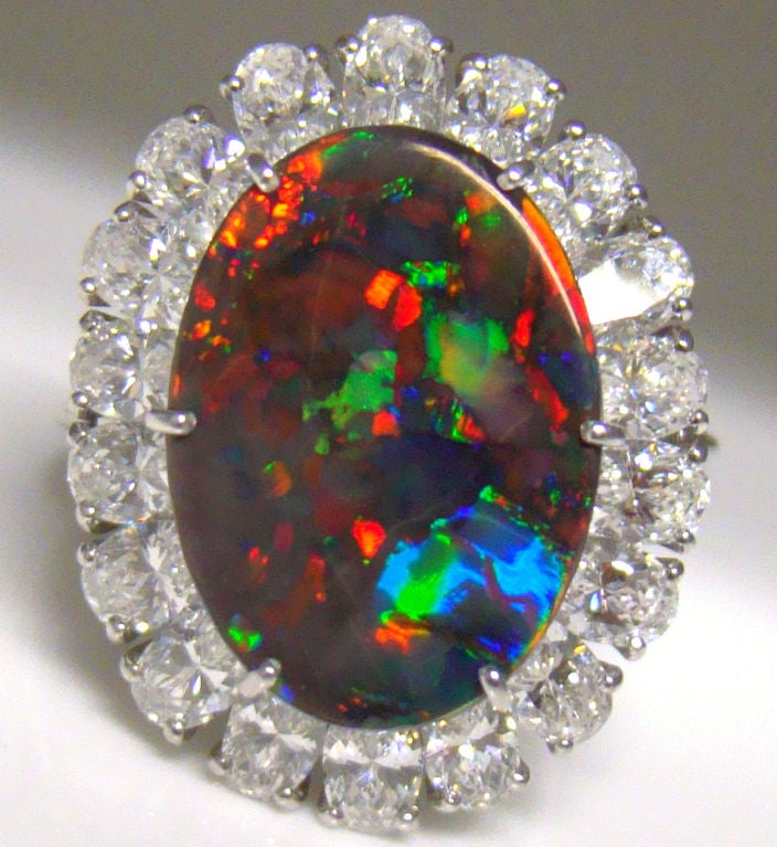Ring set with a rare and fine large oval Black Opal set surrounded by round diamonds by Cartier