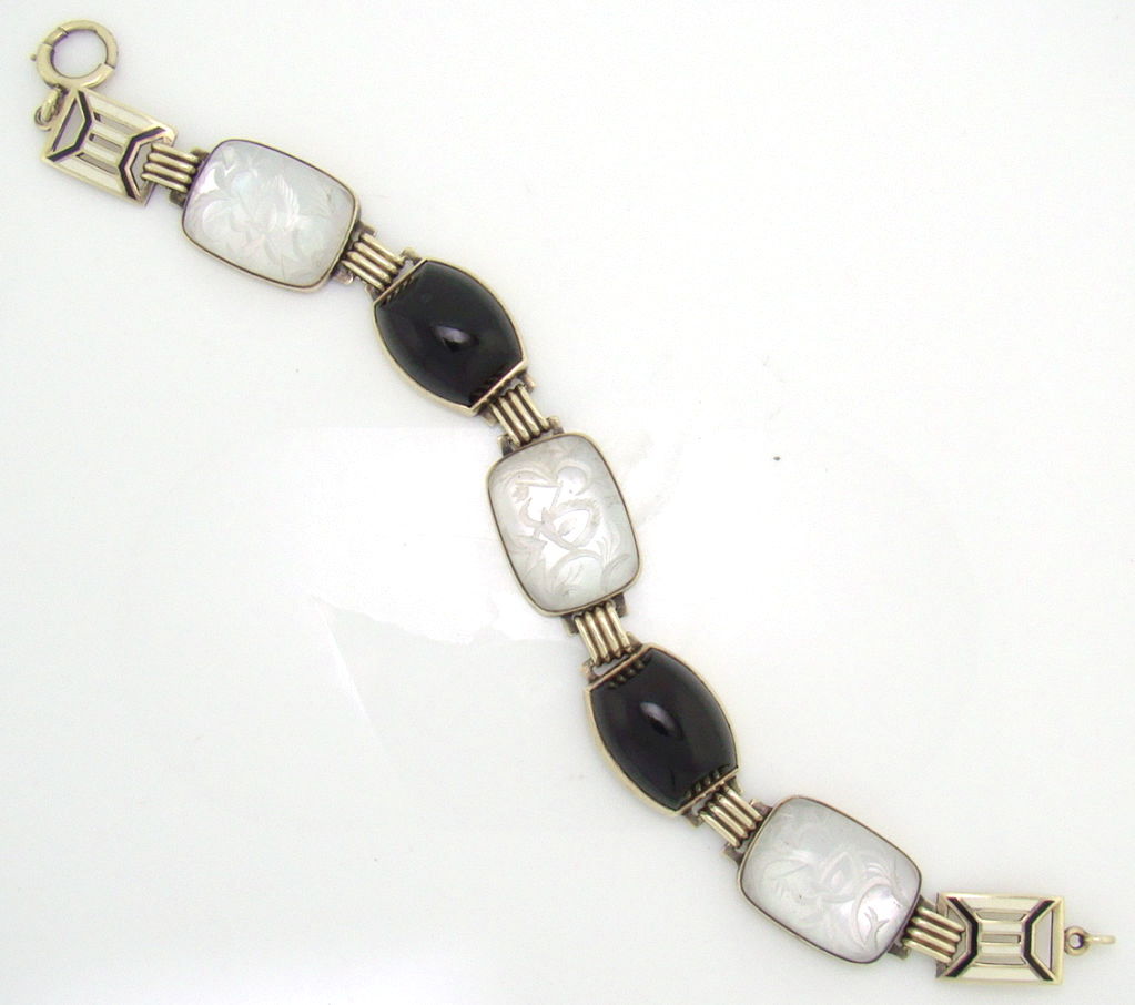 This bracelet utilizes an integration of Rock Crystal overlaid on Mother of Pearl, combining luster and light into what appears to be an unusually mesmorizing stone. Set off by contrasting black Onyx, the luster from the underlying Pearl 