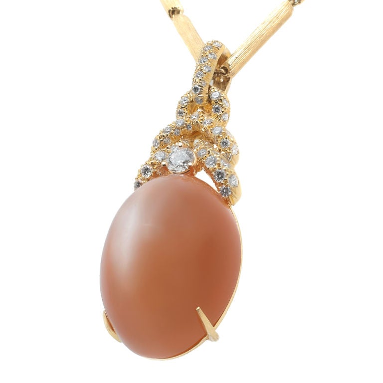 Henry Dunay, noted for his impressive work with large colored stones, is a highly collectable American designer. This breath of Spring pendant is made with 18 Karat Yellow Gold featuring a natural cabochon tangerine moonstone weighing 45.26 carats