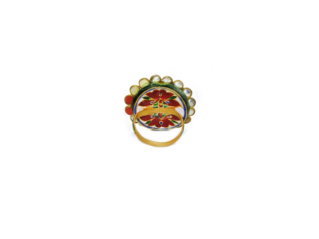 This Indian inspired ring has a ruby center with 9 stones representing the 9 planets set in a flower design surrounding it finished with an enamel cover on the shank and back of it . Size 6.25.