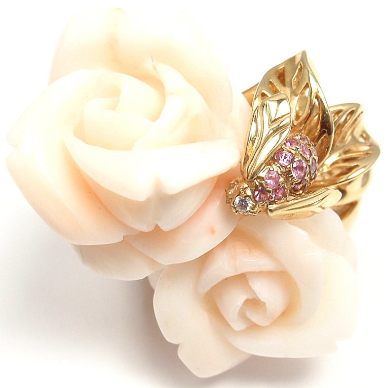 18k Yellow Gold Rose Pre Catelan White Coral, Diamond and Pink Sapphire Ring by Christian Dior. This ring comes with an original Dior box and a certificate of authenticity. With Two White Angel Skin Coral Flowers: 25x25mm and 20x20mm. Four round