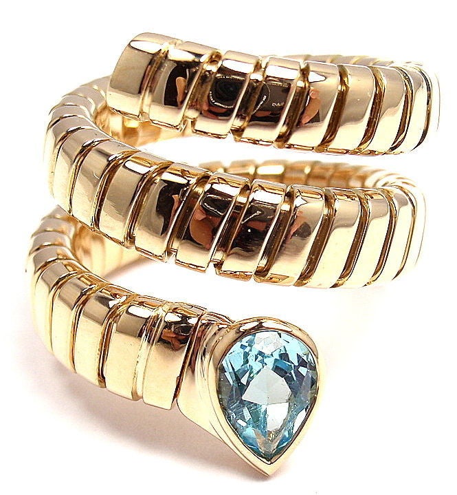 18k Yellow Gold Blue Topaz Coil Snake Ring by Bulgari. With one beautiful pear-shaped Blue Topaz stone. 

Details: 
Ring Size: 6-9 (the ring stretches)
Weight: 17.3 grams
Measurements: 9mm - 17mm at widest point
Stamped Hallmarks: Bulgari 750