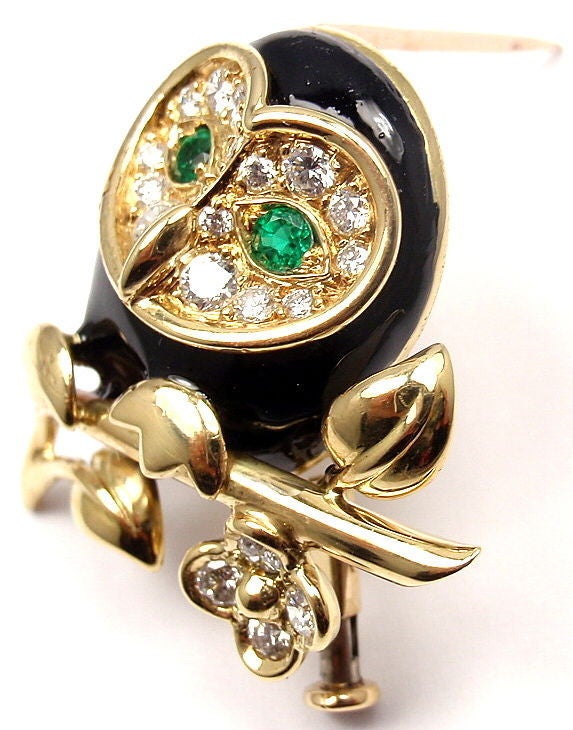 18k Yellow Gold Owl Diamond, Emerald, and Enamel Brooch Pin by Van Cleef & Arpels. With 19 round brilliant cut diamonds, VVS1 clarity, E color. Total Diamond Weight: .75CT. 2 Round Emerald Stones. Black Enamel.

Details: 
Measurements: 1
