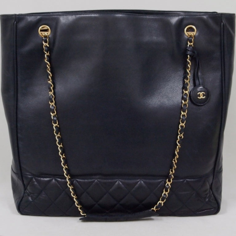CHANEL PARIS Dark navy leather large quilted bottom shopper tote bag.  Signature, polished gold and leather straps with round leather logo charm at strap end.  Dual interior pocket construction