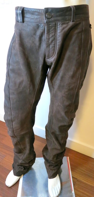 JOHN GALLIANO Dark brown goat skin leather pants for men.  Button front fly construction with zipper detail at front belt loop.  The leather is a thick, rigged leather skin with intentional grain and wrinkling.  Raw edge poplin detailing at pocket