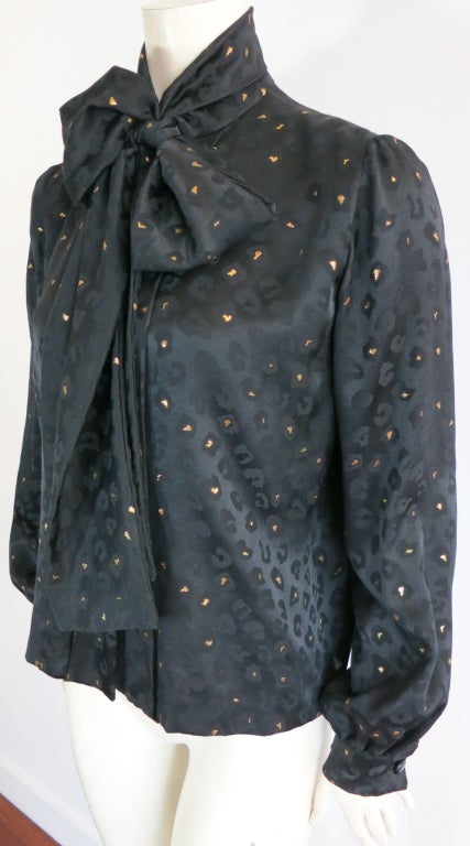 Vintage PAULINE TRIGÉRE black & metallic gold jacquard silk blouse featuring leopard pattern.  Volume silhouette with attached neck scarf detail.  Concealed front, button down placket with inverted pleat at back.  

Underarm to underarm: 20-1/2