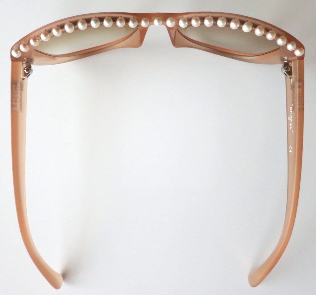 Unworn CHANEL PARIS encapsulated fresh water pearl sunglasses with frosted peach frame, and brown gradient lenses.  The top edge of these magnificent sunglasses feature a single row of fresh water, cultivated pearls that are screwed into place