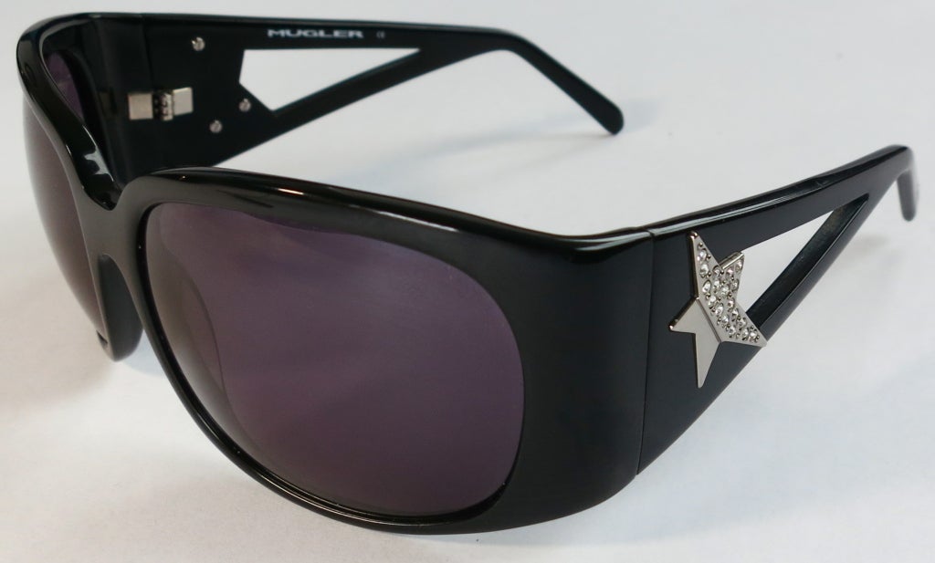 THIERRY MUGLER Jet black wrap around sunglasses with Swarovski crystal star embellished silver side temples.  Cut out style temples wit signature logo at temple tips.  Complete with the original logo embossed carry case.

In excellent condition