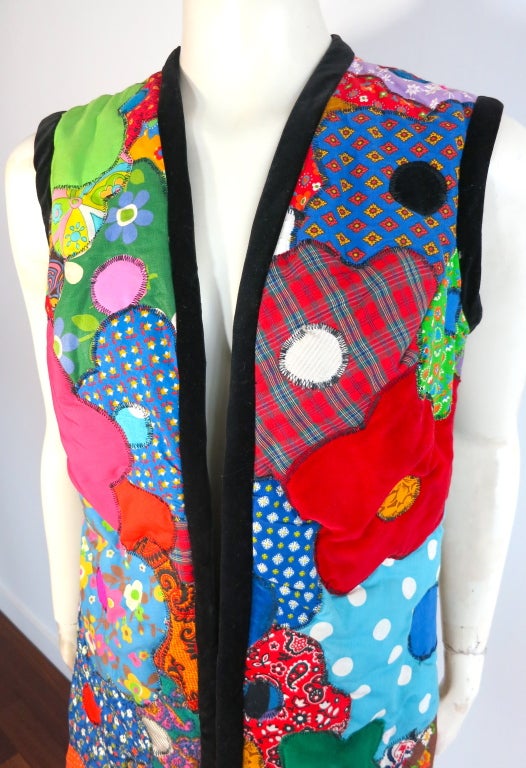 Truly one of a kind, vintage 1970's flower power quilted patchwork vest with black velvet border trim.  Lightly padded with exquisite patch work construction in the shape of flowers using a multitude of different floral, dotted, paisley, and solid