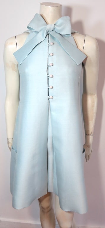 Vintage GEOFFREY BEENE 1960's Celeste/pale turquoise silk bow tie dress.  The silk fabric has a luminous, iridescent sheen to the face in a fresh, icy blue/green turquoise tone.  The front placket features matching dome buttons with loop closures. 