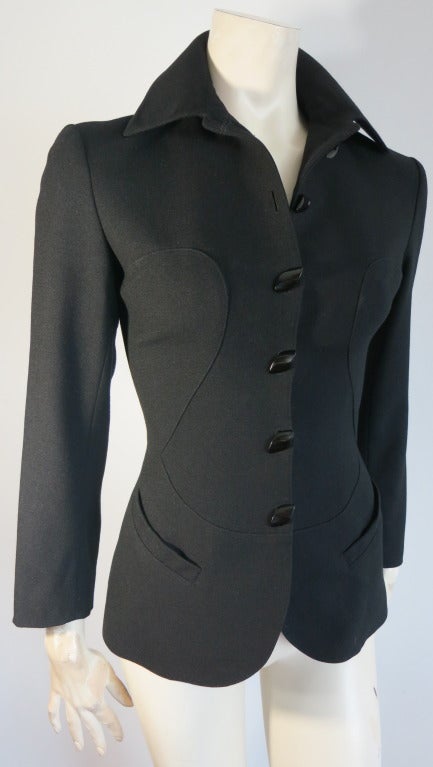 Vintage AZZEDINE ALAIA 1980's black wool curved seam blazer with shaped button closures.  Extreme fitted waist silhouette with dual waist level pockets.  Fully lined with metal clip style buttons at back tail.

Made in France

FR 36 = US 4

In