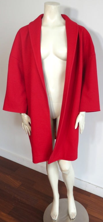 Vintage YVES SAINT LAURENT 1970's red wool cocoon coat.  Open front design with oversized, cocoon silhouette.  Concealed side seam pockets. Fully lined in orange/red lining.  

Made in France

Measurements:

Underarm to underarm:  27