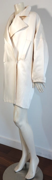 YVES SAINT LAURENT Pearl silk satin cocoon coat.

Luxurious silk satin face with silk charmeuse lining in a gorgeous ivory.

Concealed front opening with button and snap inside closures.

Dual, side pocket openings at front.

Oversized,