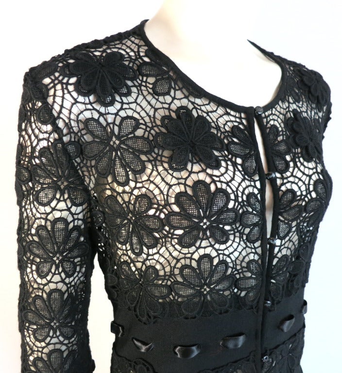 Unworn CHRISTIAN DIOR Black embroidered lace effect semi-sheer coat dress.

This stunning coat dress features an all over, semi-sheer floral artwork embroidery.  Beginning at the waist, the coat is blocked in alternating rows of solid knit wool