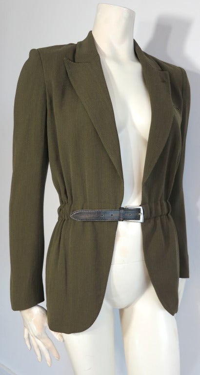 JEAN PAUL GAULTIER Olive jacket with encased leather waist belt.

Fully functioning leather belt with adjustable fit buckle front that is encased, and sewn into the layers of the jacket.

Peak lapel front shape with signature locker loop detail