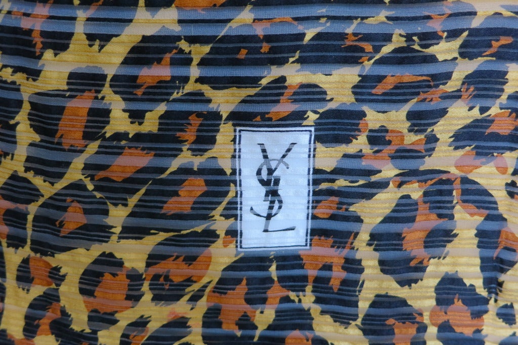 Vintage YVES SAINT LAURENT 100% silk leopard face scarf featuring all over-animal print upon semi-sheer shadow stripe fabrication.  Solid border edge with prominent YSL logo printed square at corner.

In excellent condition with no