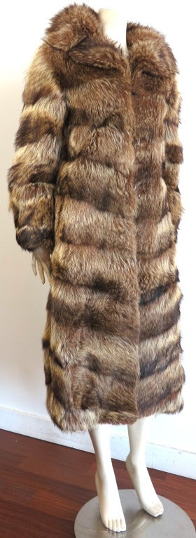 Vintage/mint REVILLON PARIS 1950's era raccoon fur full length coat.

In excellent condition inside and out with no holes, rips, or repairs.

Concealed, four locking metal hook and ring hardware closures at center front.  Solid leather trim at