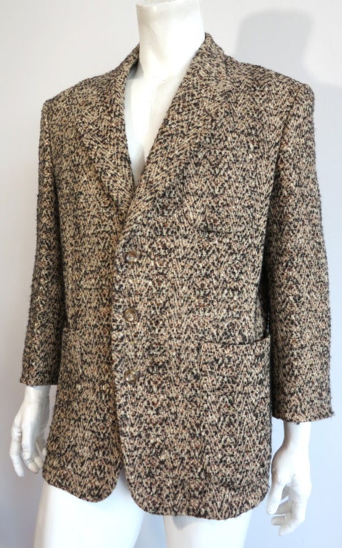 Vintage MATSUDA JAPAN Herringbone tweed jacket.  The thick tweed fabric base features beige wool warp yearns with curly black bouclé yarns as well as darker orange yarns running through the weft.

Dual waist level curved, patch pockets with left