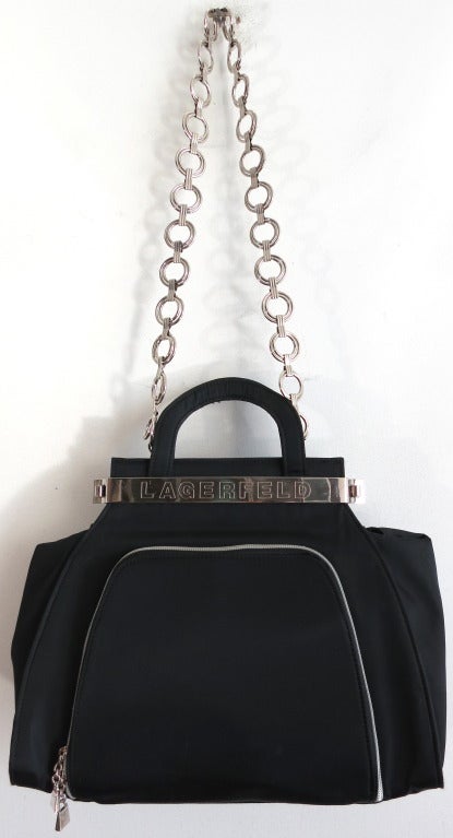KARL LAGERFELD 1980's black & silver purse handbag featuring prominent 'LAGERFELD' engraved front silver plate, and metal hoop chain shoulder strap.

The top metal plates at front and back lock/unlock at the cylindrical side closures at both ends.