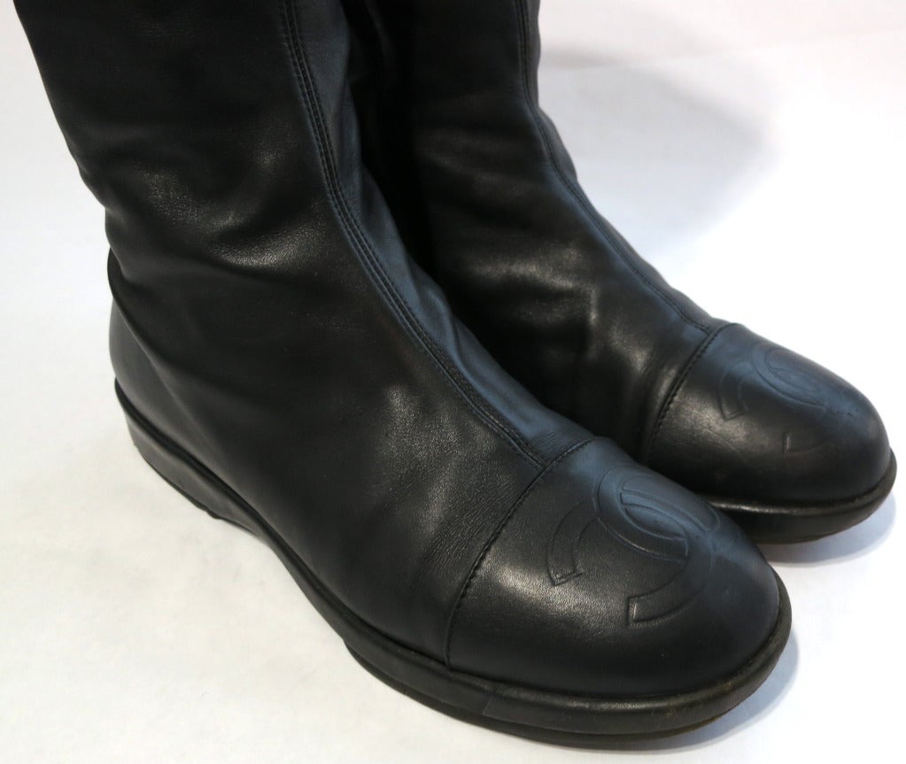 CHANEL 1990's era black leather motorcycle style boots with quilted top cuffs. 

The top quilted cuffs are stitched down to the center back edges of the main boots, and act as a over sleeve to the main boot.  Both cuffs feature twin, logo engraved