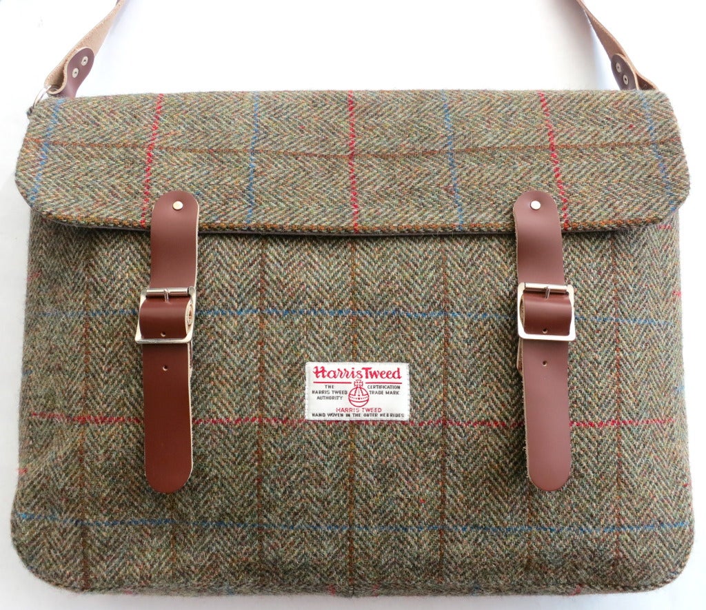 New/Unused HARRIS TWEED Made in Scotland herringbone satchel with adjustable leather straps.  Twin leather snap down, buckle straps with Harris Tweed label patch front.  

Fold over top with twin internal slot pocket storage.

Lined in gray