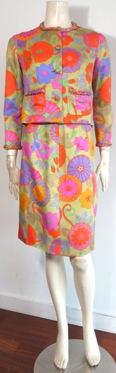 Early 1960's HANAE MORI Ginza Tokyo Silk floral skirt suit with excellent braided detail at neckline, cuffs, and pockets.

Gorgeous multi-color floral printed silk twill with self fabric covered dome buttons at front.

Concealed snaps at front
