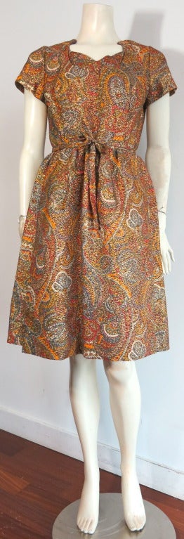 Gorgeous vintage GEOFFREY BEENE 1960's Metallic brocade paisley dress.  

Beautiful scooped neckline with cross front, layered inset at neckline.  

Self fabric waist tie sash.  

Concealed center back zipper entry.  

Fully lined in dark