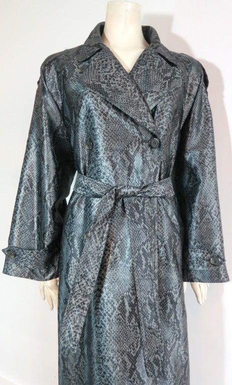 Vintage YVES SAINT LAURENT Snakeskin python printed trench coat & belt.

This excellent condition trench coat features a double breasted front with horn button closures, and shoulder epaulet detailing. Button tab detailing at cuffs, and dual waist