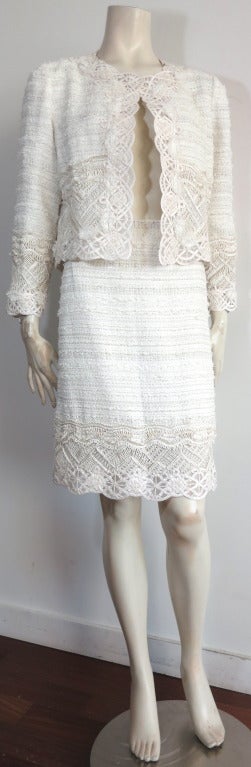 Unworn OSCAR DE LA RENTA Ivory & platinum silk skirt suit.

This beautiful skirt suit features a gorgeous ivory base cloth with rows of metallic platinum colored threads and short ivory fringe running along the warp.  

The border edges of the