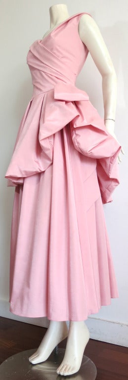 Vintage CHRISTIAN DIOR Ball gown designed by Marc Bohan in the 1980's.

This stunning light pink gown features a voluminous top-skirt detail which ascends over the main, long skirt of the dress.  A single bow-tie style loop is draped at the