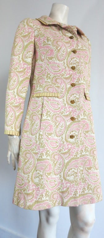 Vintage I. MAGNIN & CO. 1960's Paisley tapestry weave coat.

This excellent condition coat features a lovely paisley artwork in ivory ground with pistachio green and sherbet pink detail.

The collar, cuffs, and flap edges feature box-pleated,
