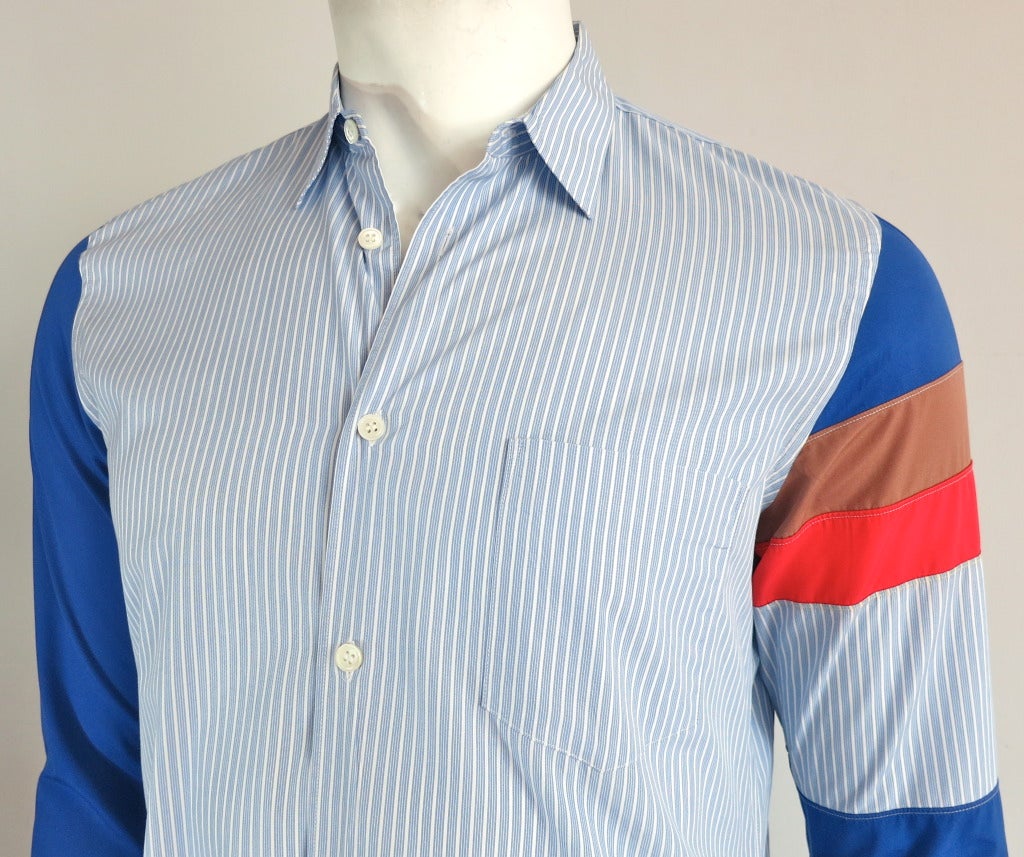 COMME DES GARCONS Men's color-blocked dress shirt.

Blue striped dress shirt with bold color blocked paneling at the sleeves.

Button front closures with left chest patch pocket detail.

Made in France, as labeled

*MEASUREMENTS*
Labeled a