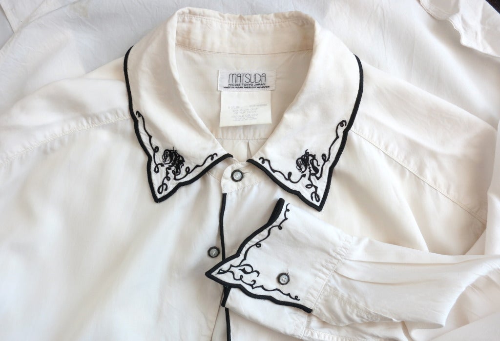 Collectible vintage MATSUDA Men's embroidered silk shirt.

The shirt was designed by Mitsuhiro Matsuda in Japan during the 1980's.

This fair condition shirt features an ivory silk blend base cloth with contrast, black, satin edge stitch