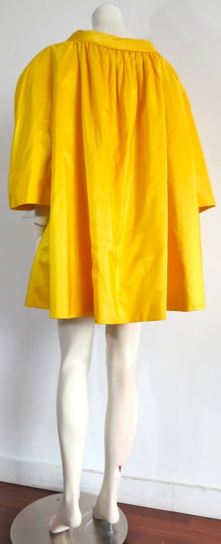 Vintage ARNOLD SCAASI Imperial yellow silk taffeta evening coat.

This luxurious coat was designed by Arnold Scaasi in the late 1970's-early 1980's.

The fabric is a compact, silk taffeta, with a beautiful iridescent quality to the fabric