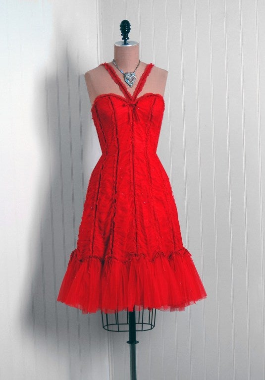 Breathtaking ruby red cocktail dress from the iconic Bellville Sassoon label dating back to the mid-1990's. This garment is fashioned from fully-lined ruched micro-sequin tulle with stunning velvet trimming. I love the seductive low-cut plunge