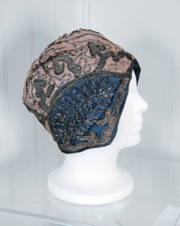 You will make an unforgettable entrance in this one-of-a-kind 1920's cloche hat. Elaborately embellished with silver metallic soutache-braids and fabulous elongated bugle-beads that have tortoise-shell ends and crystal centers. The fashion magazines