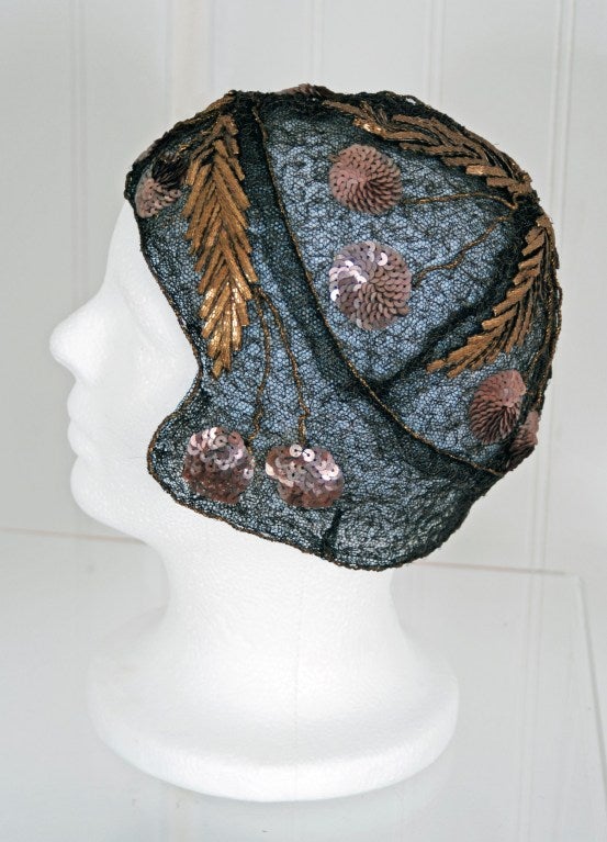 Breathtaking 1920's metallic-gold lame & black net-tulle  flapper semi-sheer cloche hat. This is, without a doubt, the most extraordinary antique cloche I have ever laid my eyes on. Sparkling sequin cherries with embroidered 3-D leaves in the most