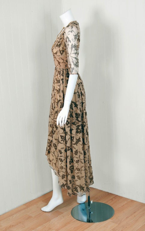 Gorgeous early 1970 Thea Porter dress fashioned in metallic-gold and beige art-nouveau floral print pure-silk. I love the low-cut plunge and heavily-smocked shoulders. The silhouette is a flattering nipped-waist hourglass tea-length with a draped