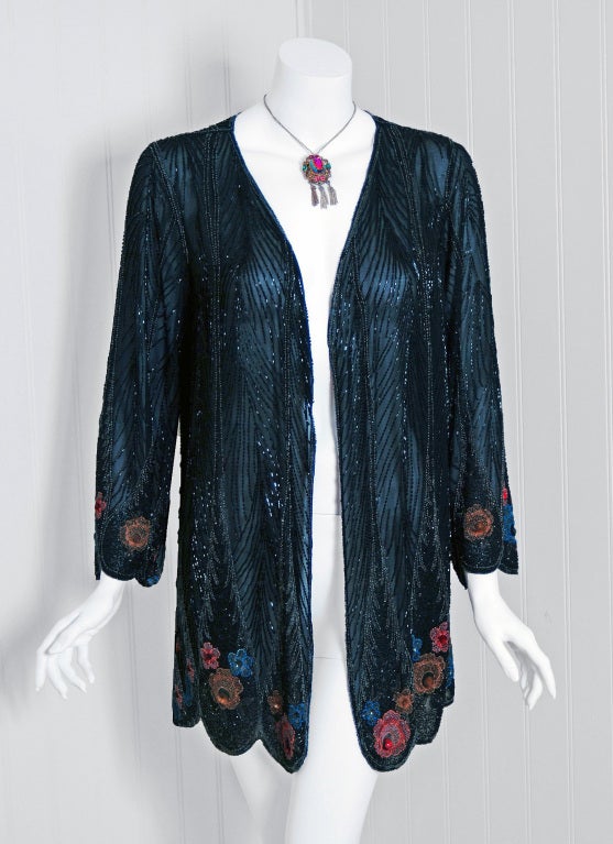 Art-Deco at its best! This stunning jacket is covered with a profusion of beadwork in shades of black,rose,marigold,blue and clear-crystal. The flowers are accented with sequin clusters which sparkle beautifully. This jacket is fashioned from