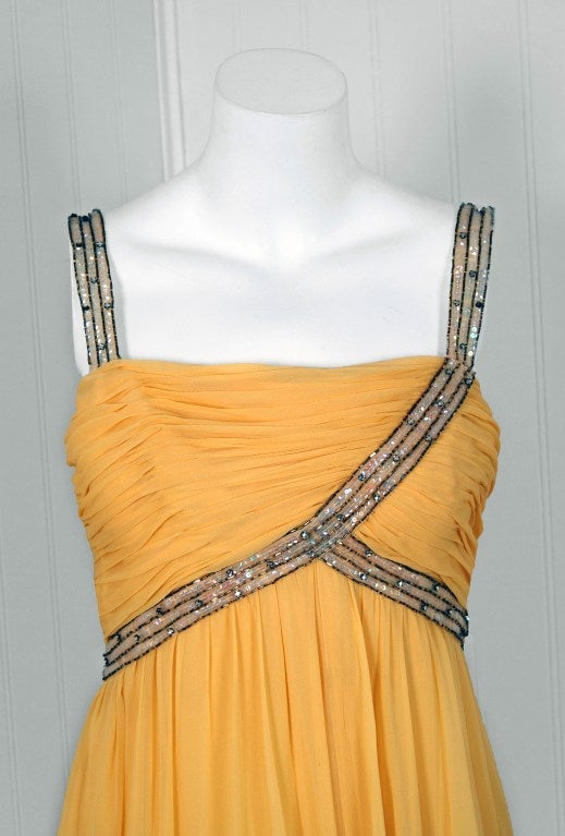 This breathtaking 1960's lemon-yellow designer silk-chiffon goddess tea-gown is a perfect statement dress. The flattering bodice is a heavily-ruched low-cut boned plunge. Hundreds of sparkling sequins & rhinestones intertwine to make the divine