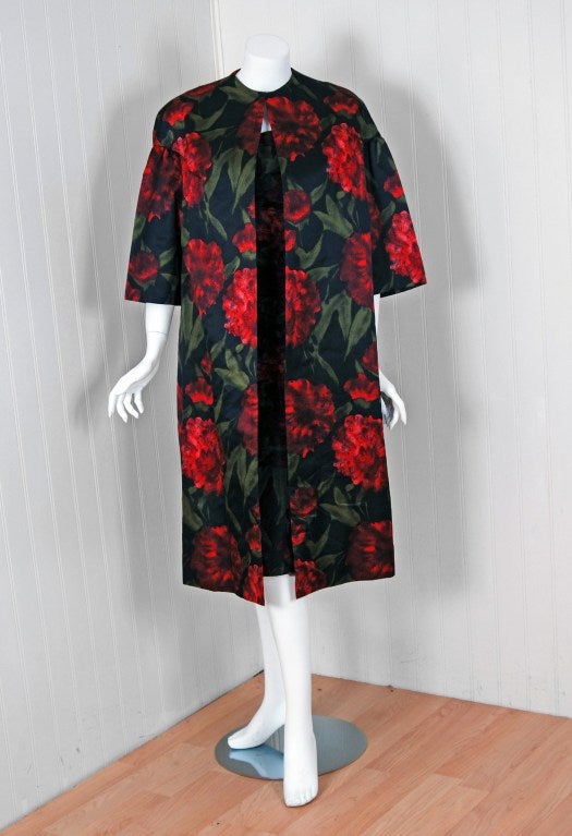 With its vivid red-roses watercolor garden print and flawless hourglass silhouette, this cocktail dress ensemble by Dweigler Modelle has the casual elegance the 1950's were known for. The bodice has a fully-boned construction with duel-straps on