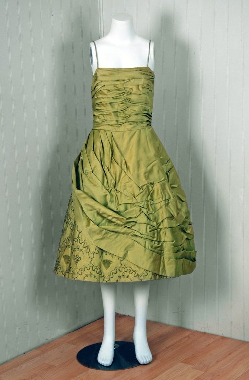 In this gorgeous 1950's chartreuse-green party dress,the detailed construction and meticulous attention to detail are comparable to what you will find in modern couture. This enchanting garment is fashioned from fully-lined shimmer silk-satin