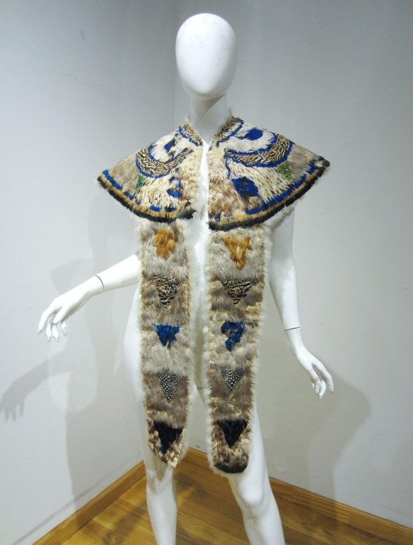 This is an incredible and ultra-rare feather cape dating back to the mid 19th century. The garment is fashioned from genuine guinea fowl and peacock; inside is lined with lightweight white feathers. This cape has a shaped neckline which would